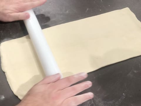 La pâte est étalée en une longue bande trois fois plus longue que large, à l'aide du rouleau à pâtisserie