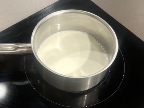 Le lait est dans une casserole qui est placée sur la plaque de cuisson