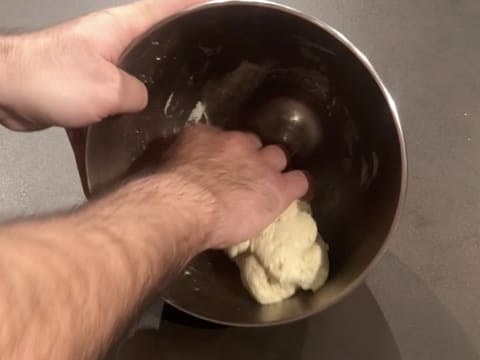 La pâte obtenue est rassemblée à la main dans la cuve du batteur qui est penchée sur le plan de travail
