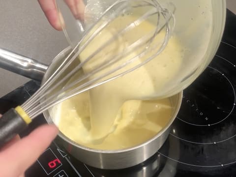 La préparation lactée est versée dans la casserole qui est placée sur la plaque de cuisson