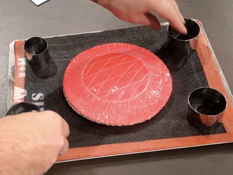 Des petits cercles à mousse sont déposés aux quatre coins de la toile de cuisson, sur laquelle est posée la galette