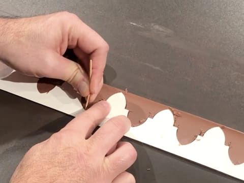 Le chocolat est marqué avec la pique en bois, en suivant le contour de la couronne royale en carton