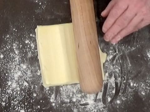 Le beurre est aplati avec le rouleau à pâtisserie