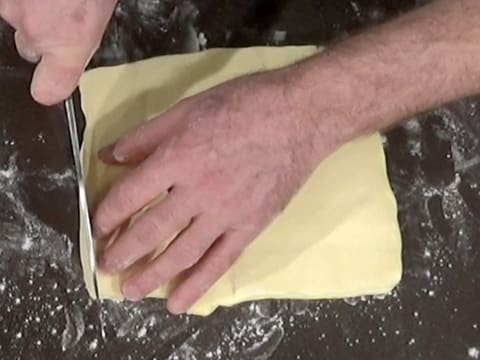 Un des bords du beurre abaissé est retaillé avec un couteau
