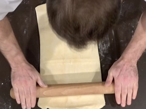 Le pâton est abaissé sur la longueur à l'aide du rouleau à pâtisserie