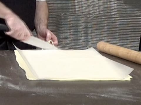 La pâte feuilletée abaissée est recouverte d'une feuille de papier sulfurisé