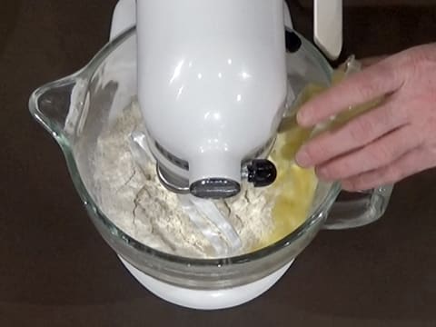 Ajout du beurre ramolli dans la cuve du batteur sur la farine