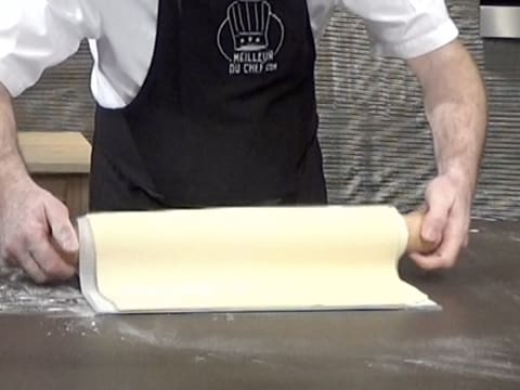 La pâte feuilletée est déroulée sur une plaque à pâtisserie