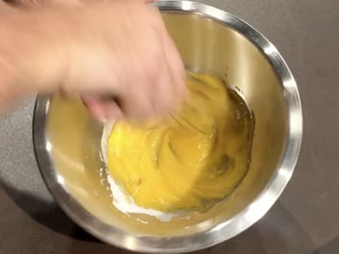 Les jaunes d'oeufs et le sucre en poudre sont mélangés ensemble au fouet