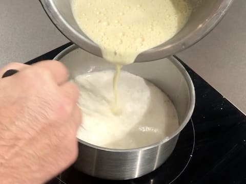 Le mélange blanchi dans le cul de poule est versé dans le restant de lait dans la casserole