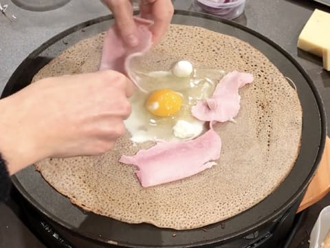 Ajout de petites boules de mozzarella ainsi que des morceaux de jambon blanc sur la galette qui cuit sur la crêpière électrique