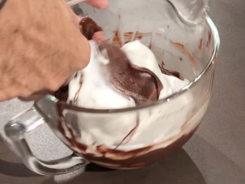 Mélange de la préparation chocolatée avec un peu de meringue à l'aide de la spatule maryse