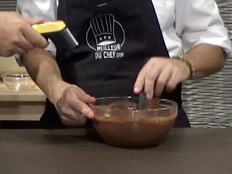 Prise de la température de la préparation chocolatée qui est mélangée à la spatule maryse dans le saladier