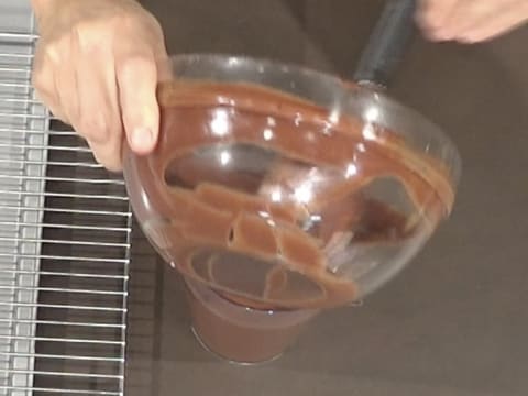 Le glaçage chocolat contenu dans le saladier est transvasé dans un pichet verseur