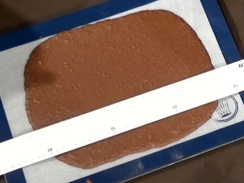 Mesure du croustillant chocolat qui est sur le tapis de cuisson en silicone, à l'aide d'une règle graduée