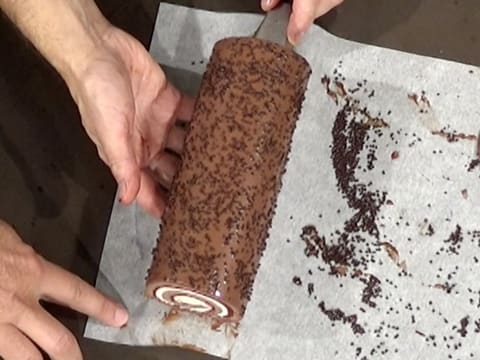 La bûche au chocolat est soulevée à l'aide d'une spatule métallique
