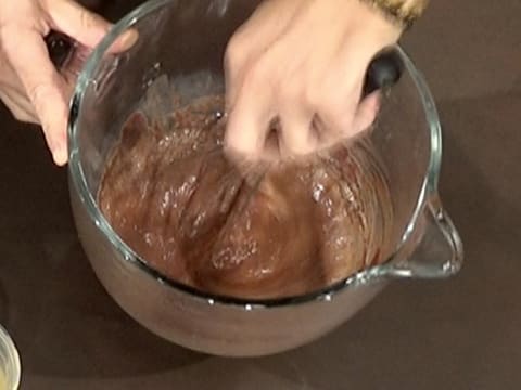La préparation chocolatée dans la cuve du batteur, est fouettée à l'aide d'un fouet à main