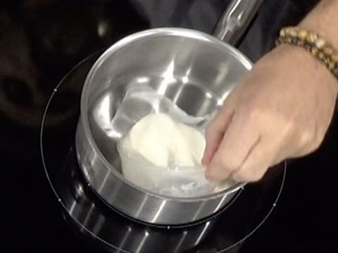 Le lait est versé dans une casserole qui a été placée sur une plaque de cuisson