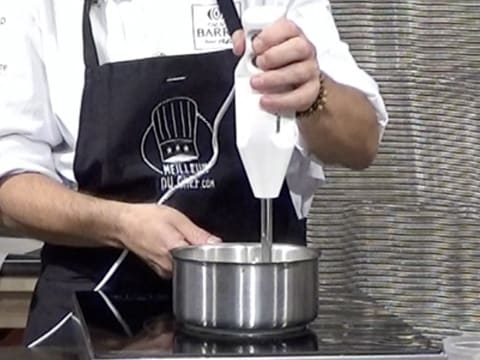 La préparation dans la casserole est mixée à l'aide d'un mixeur plongeant