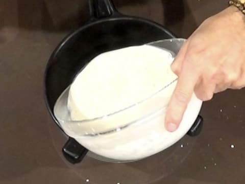 La crème est filtrée dans une passoire tamis