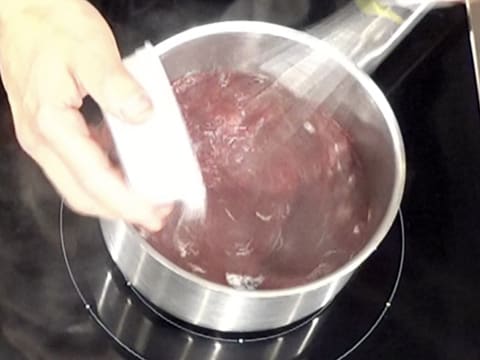 Le mélange sucre en poudre et pectine NH nappage est versé dans la casserole contenant la purée de griotte, tout en étant mélangé avec un fouet