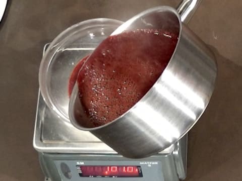 La compote de griotte est versée dans un saladier qui est placé sur une balance électronique