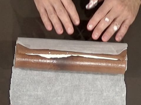 Le gâteau est enroulé de l'autre côté avec le papier sulfurisé