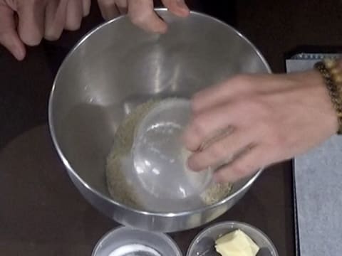 Ajout du sucre en poudre dans la cuve du batteur sur la farine et la poudre d'amandes