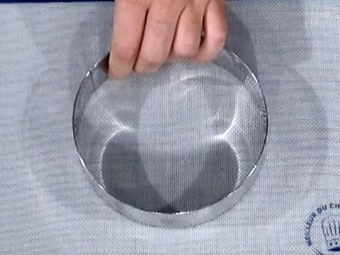 Un cercle à mousse est posé sur un tapis de cuisson silicone