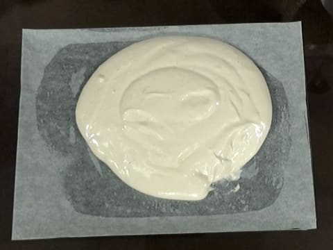 La pâte à biscuit fromage blanc est sur la feuille de papier sulfurisé graissée, sur la plaque à pâtisserie