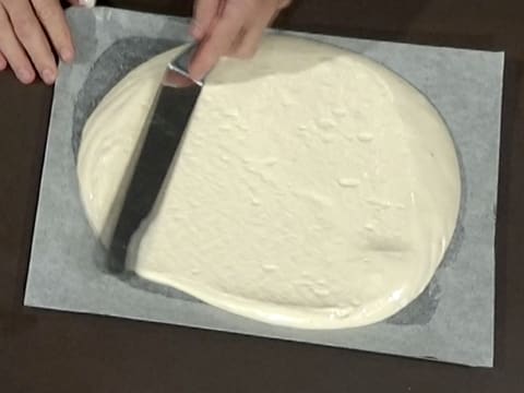 La pâte à biscuit fromage blanc est étalée sur toute la surface de la plaque à pâtisserie, à l'aide d'une spatule métallique coudée