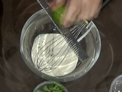 Ajout des zestes de citron vert prélevés à l'aide d'un zesteur râpe, dans le saladier, sur la crème liquide