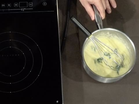 La casserole contenant la crème à la menthe et au citron vert est retirée de la plaque de cuisson
