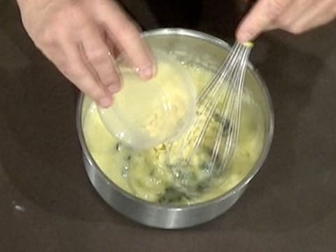 Les pistoles de beurre de cacao sont versées dans la casserole sur la crème à la menthe et au citron vert