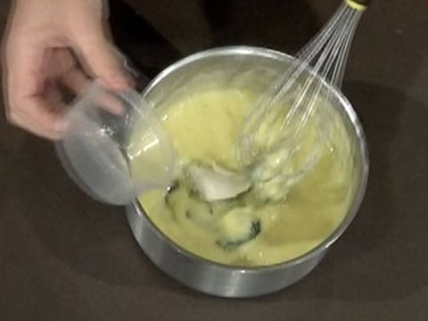 Ajout de la gélatine hydratée dans la casserole sur le mélange de crème à la menthe et citron vert et beurre de cacao et chocolat blanc