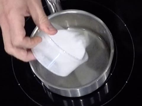 Ajout du sucre en poudre dans la casserole, sur le jus de citron vert