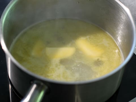 Le beurre est en train de fondre dans l'eau frémissante dans une casserole