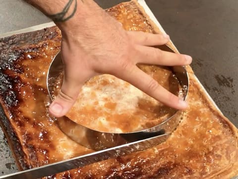 Un disque de pâte feuilletée est détaillé à l'aide du cercle à mousse et d'un couteau à dents