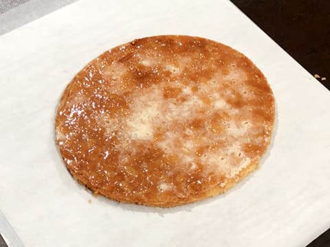 Le disque de pâte feuilletée est placé sur une plaque à pâtisserie recouverte d'une feuille de papier sulfurisé