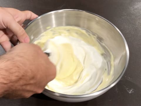 Mélange à la spatule de la crème et de la crème fouettée dans le cul de poule