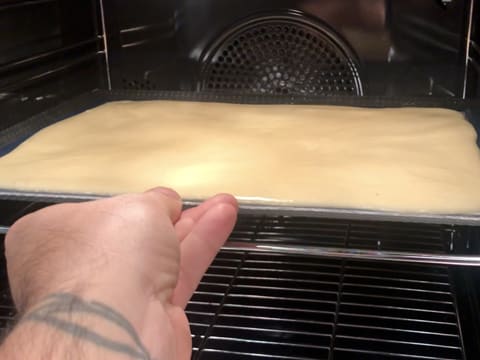 Mise de la plaque contenant la pâte à biscuit dans le four
