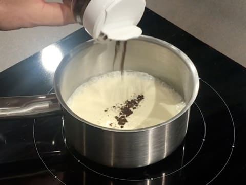 Ajout de la vanille en poudre dans la crème liquide, qui est dans une casserole