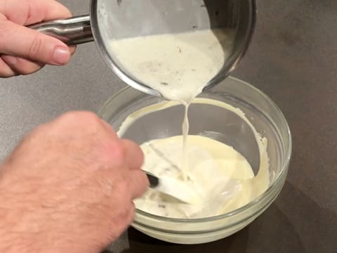 De la crème liquide chaude est versée sur le chocolat blanc fondu