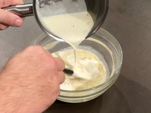 De la crème liquide chaude est versée sur le chocolat blanc fondu