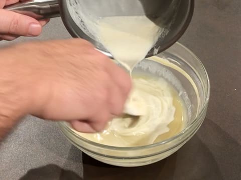 De la crème liquide chaude est versée sur le chocolat blanc fondu