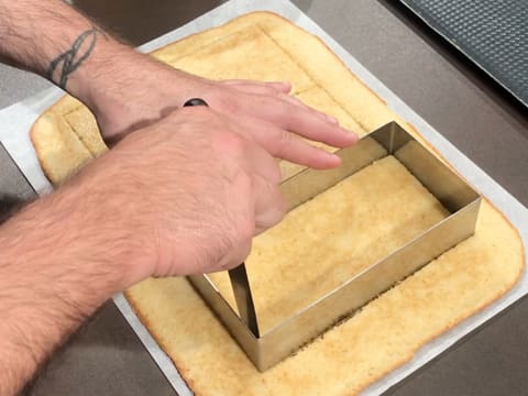 Le biscuit est coupé avec un couteau en suivant les contours du rectangle inox