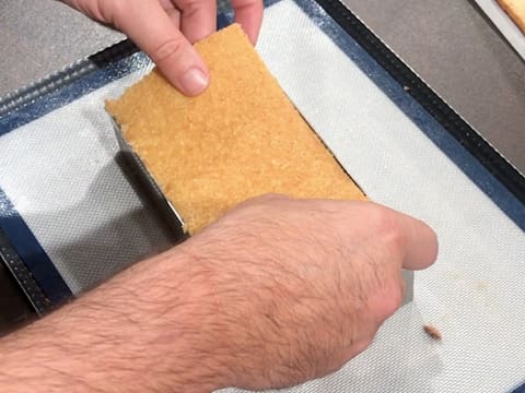 Un rectangle de biscuit est placé sur le Cara Crakine dans le cadre inox