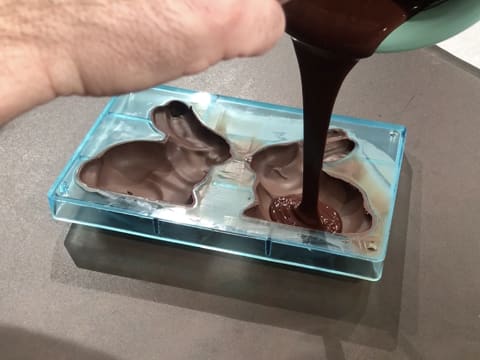 Chocolat fondu versé dans moule lapin