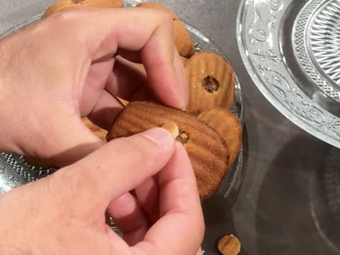 La madeleine fourrée de praliné amandes noisettes est refermée avec l'opercule en pâte de madeleine