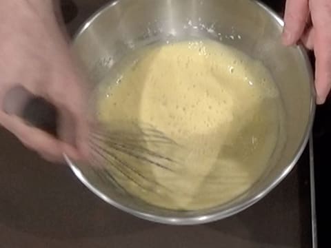 La préparation à base de jaunes d'oeufs, de sucre en poudre et de lait est mélangée au fouet